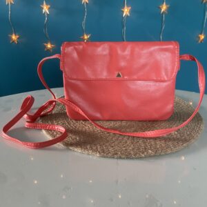 Petit sac en bandoulière couleur corail avec fermoir doré en forme de triangle